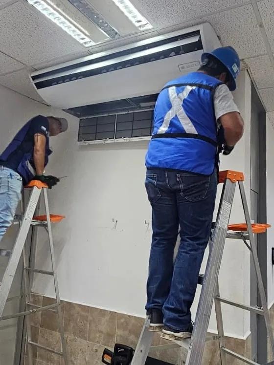 Dos técnicos instalando sistema de climatización en techo